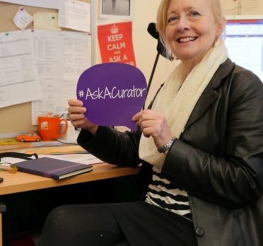 Image: woman in office holding purple sign