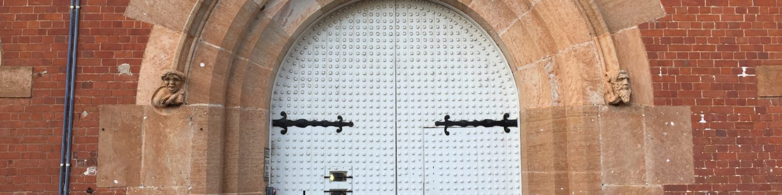 Image: large arched door sent in brick wall