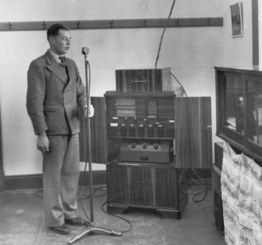 Image: young man standing in front of a microphone