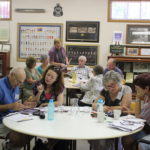 Group of people working around table.