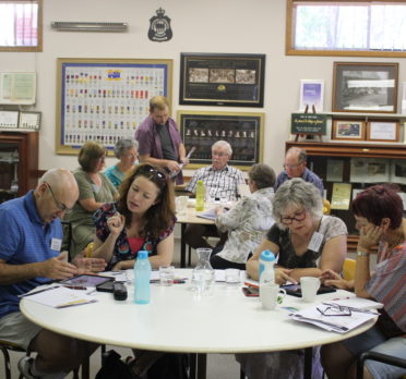 Group of people working around table.