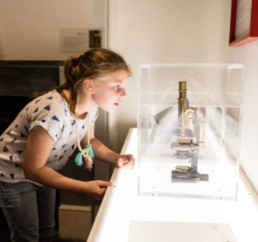 Young Child peering at a microscope