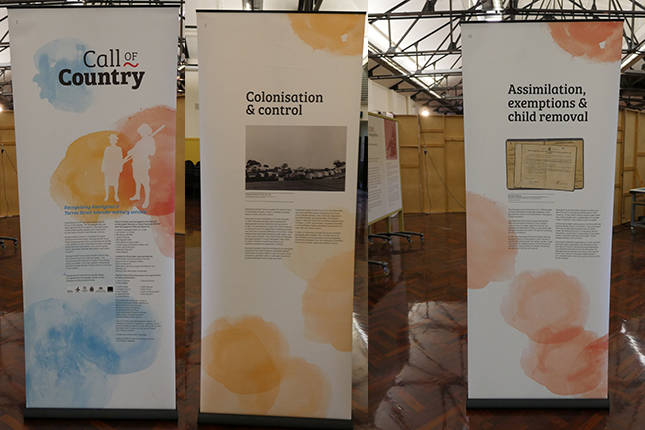 Collage of three banners on display in large hall.