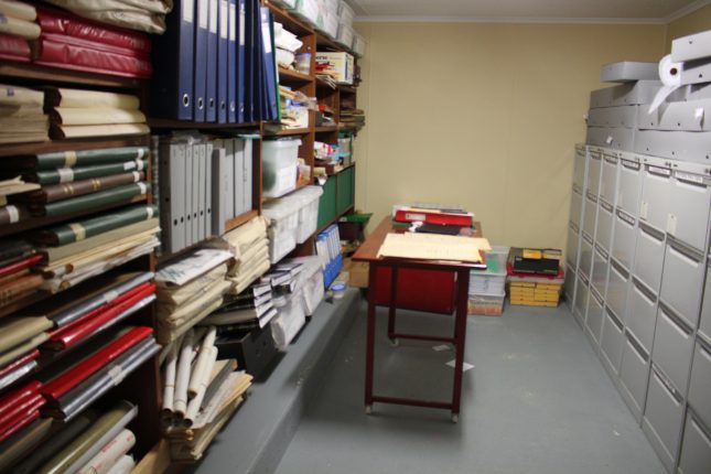 Storage area with shelves full of neatly stacked folders and other material