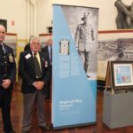 Men standing next to a pull up banner