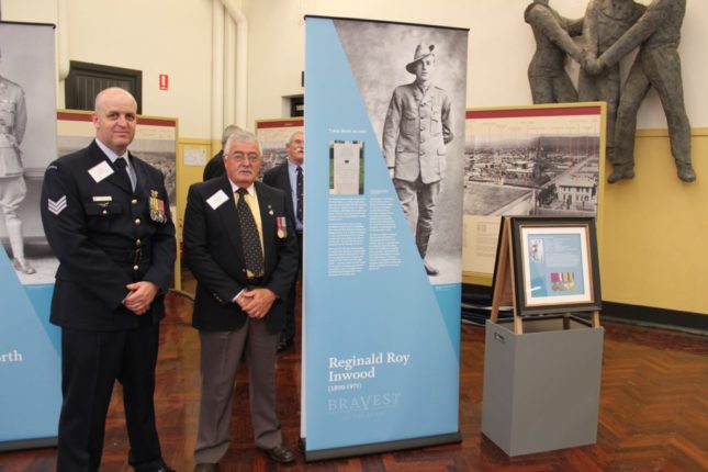 Men standing next to a pull up banner