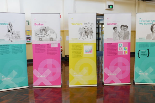 Row of five pull up banners in bright pink, aqua and yellow.