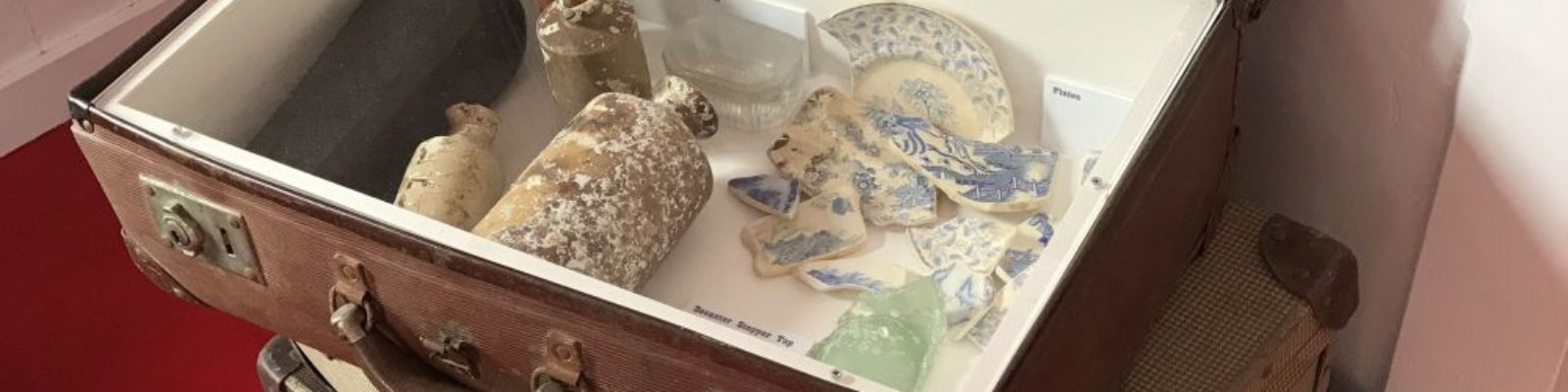 Stack of suitcases showing items salvaged from a shipwreck on display