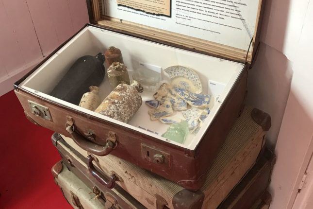 Stack of suitcases showing items salvaged from a shipwreck on display