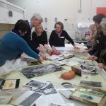 Table full of photos and other material soaked in water