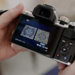 Digital camera being held up to show two embroideries on the screen